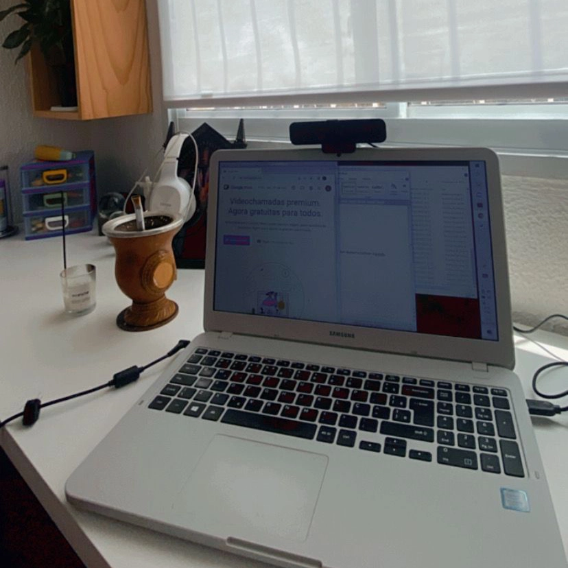 foto de um notebook sobre uma mesa de canto e objetos sobre ela